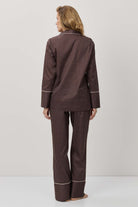 Person wearing a brown checkered pajama set on a white background