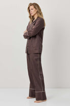 Woman wearing a brown checkered pajama set on a white background