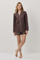 Woman wearing a brown checkered pajama set on a white background