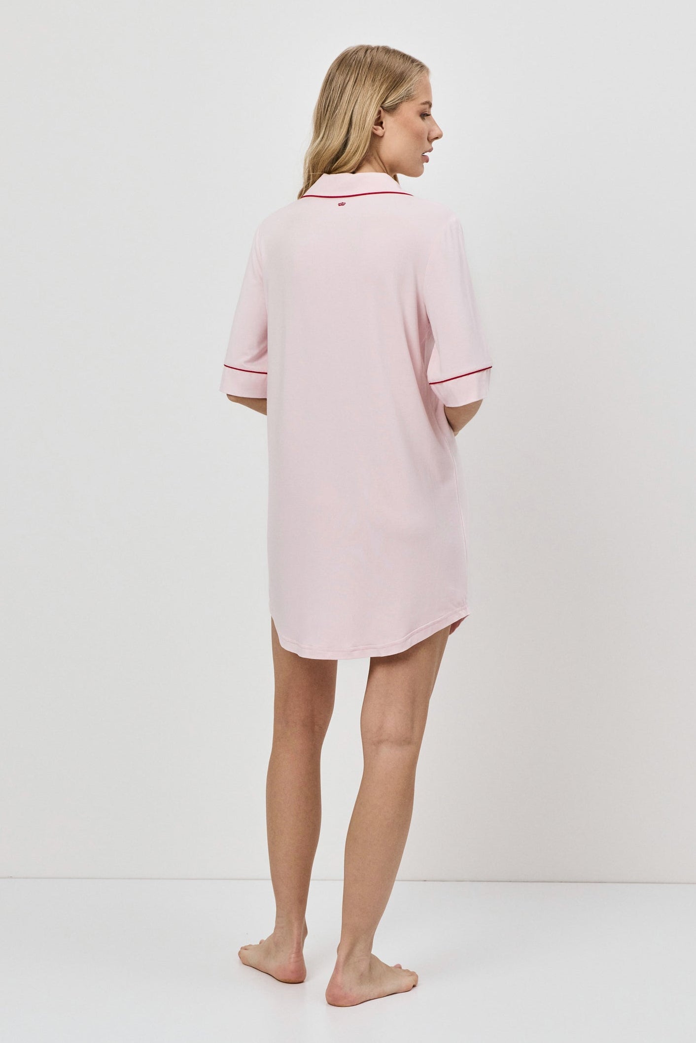 Person wearing a pink nightdress against a white background