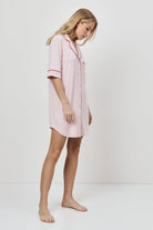 Woman wearing a pink nightshirt on a white background