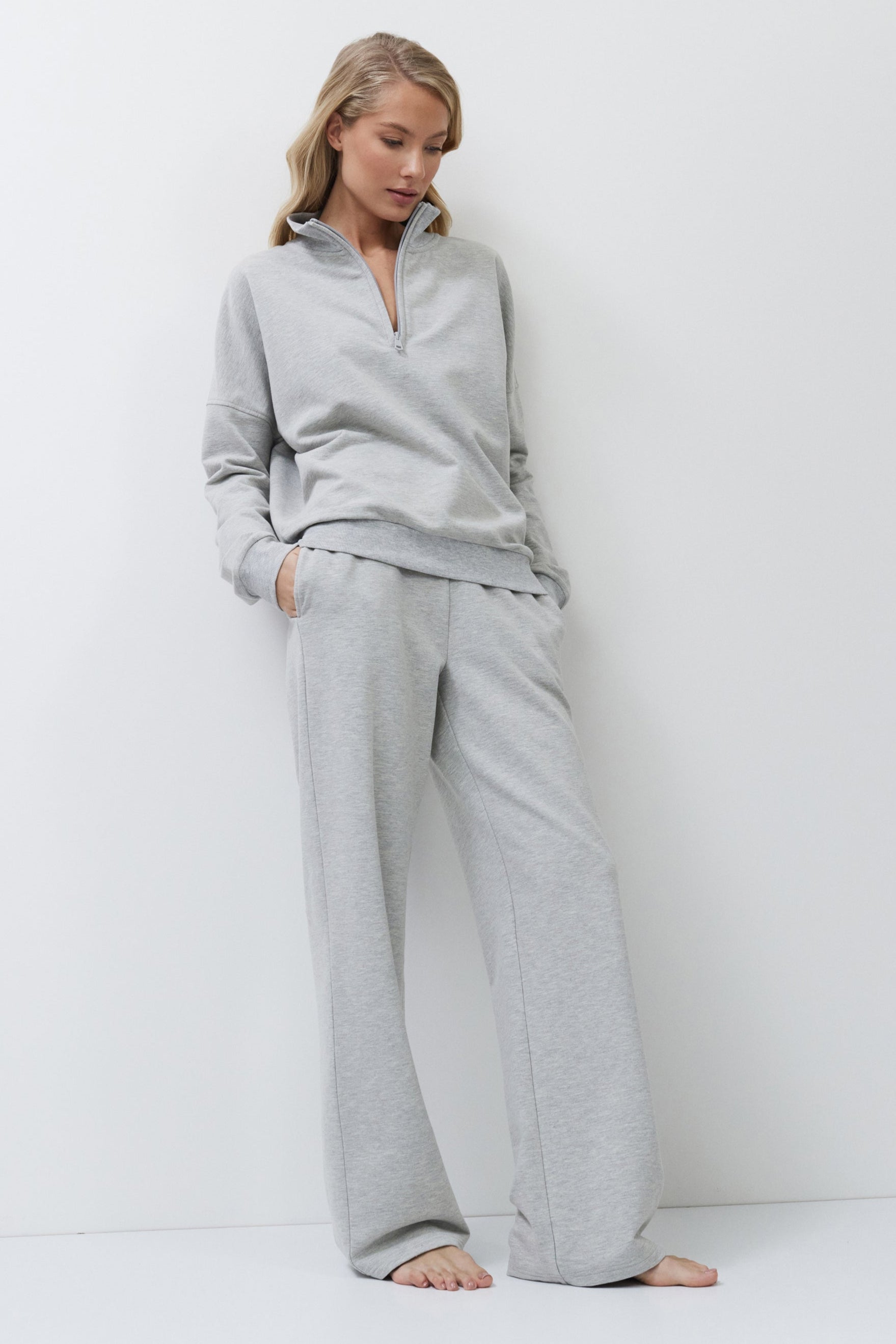 Woman wearing a gray loungewear set on a white background