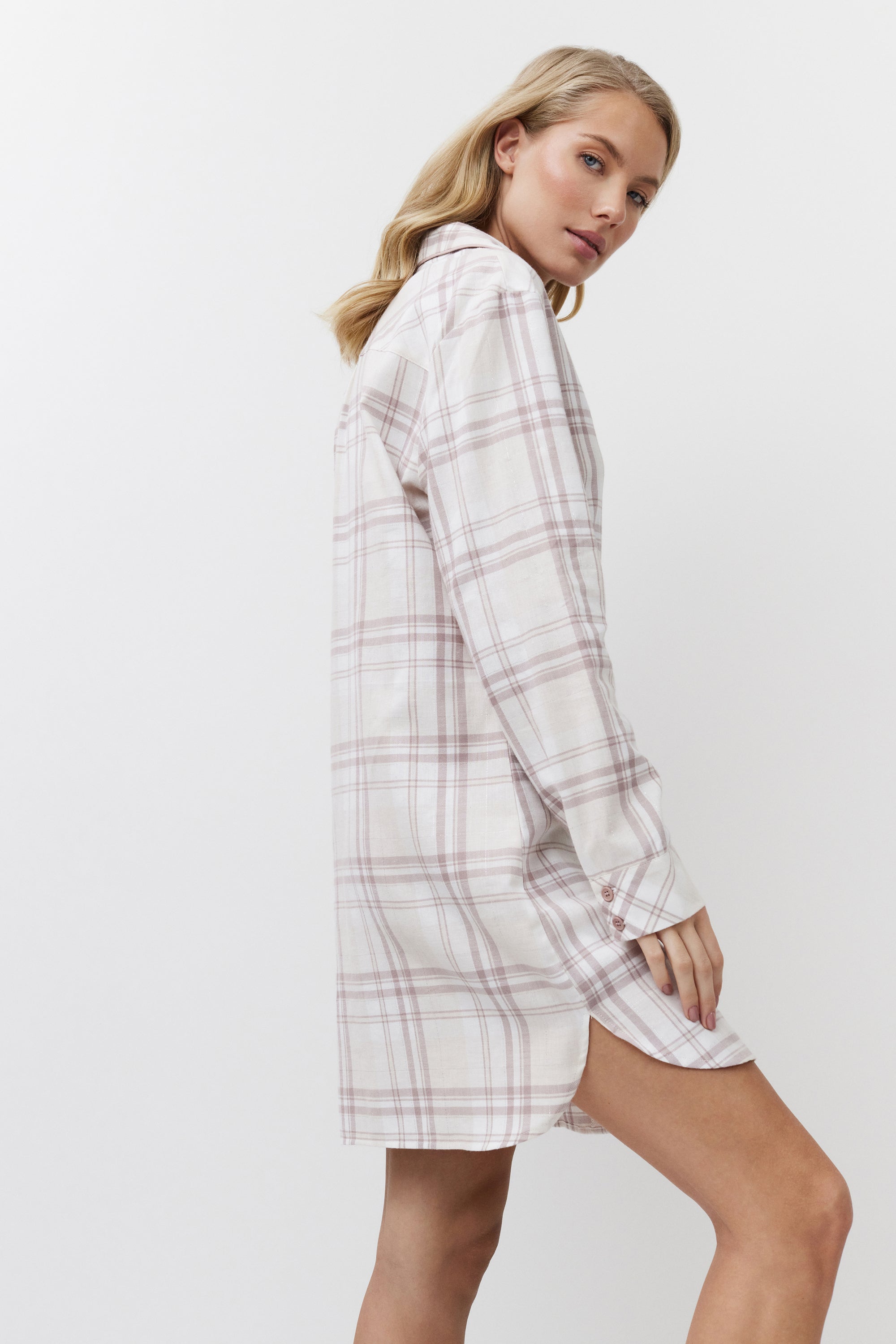 Woman wearing a plaid shirt dress on a white background