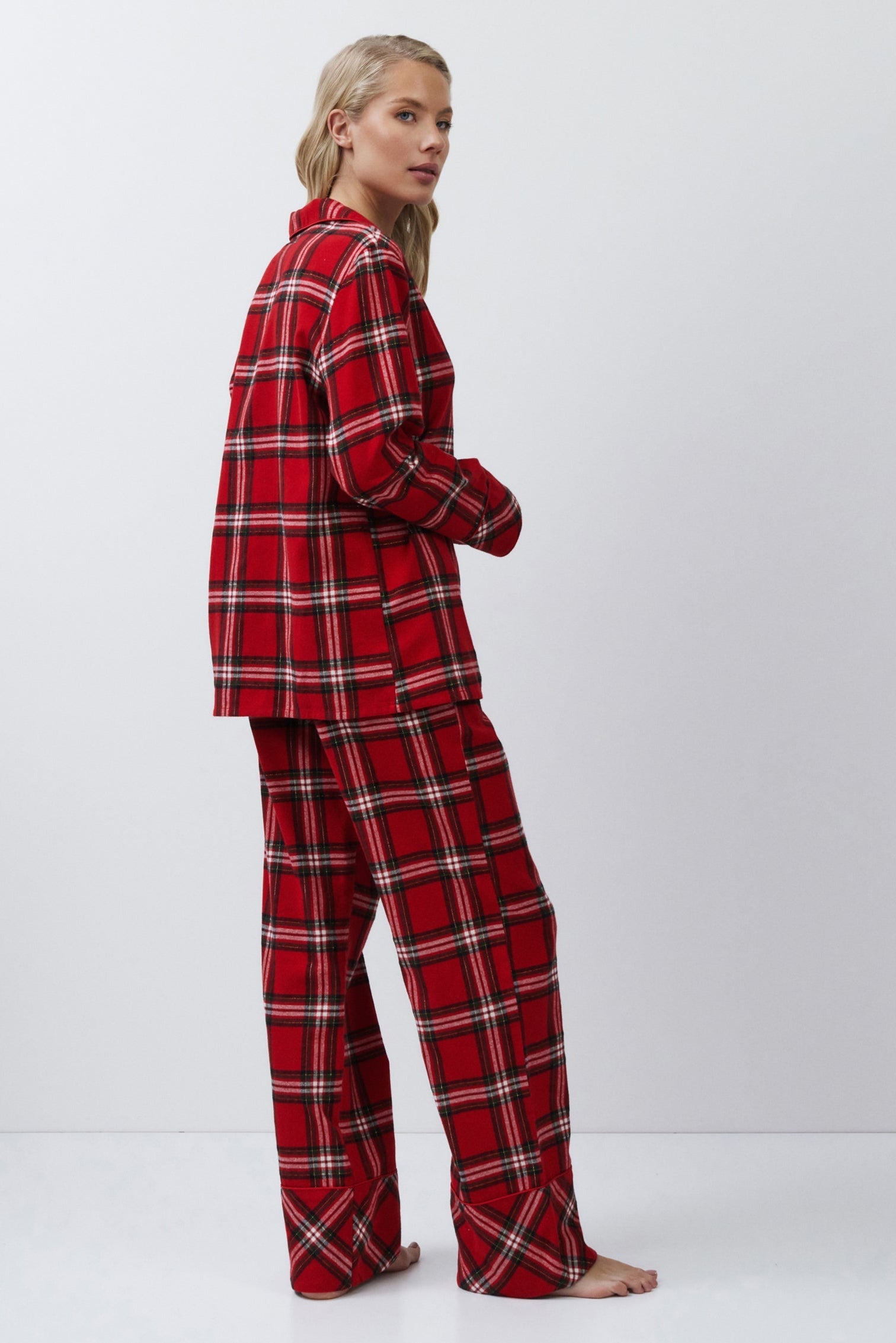 Person wearing red plaid pajamas on a white background