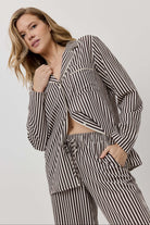 Woman wearing a black and white striped outfit on a plain background
