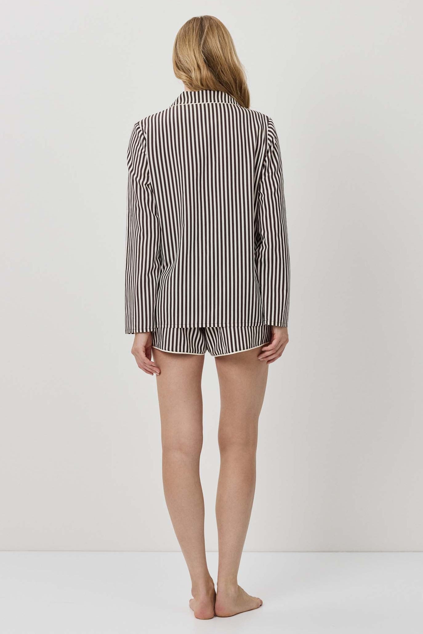 Person wearing a striped shirt and shorts on a plain background