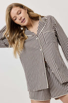 Woman wearing a black and white striped outfit on a plain background