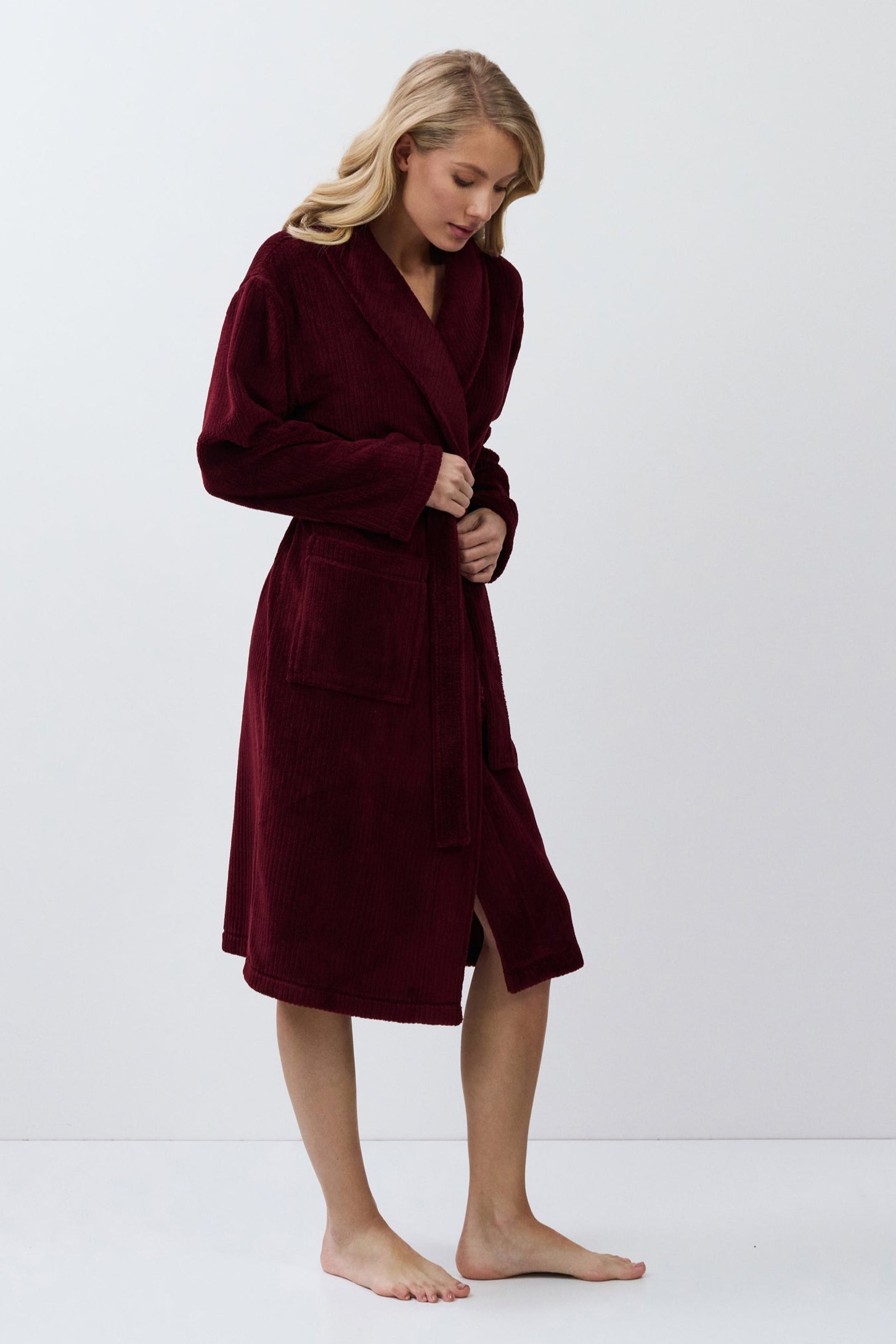 Person wearing a burgundy robe on a white background