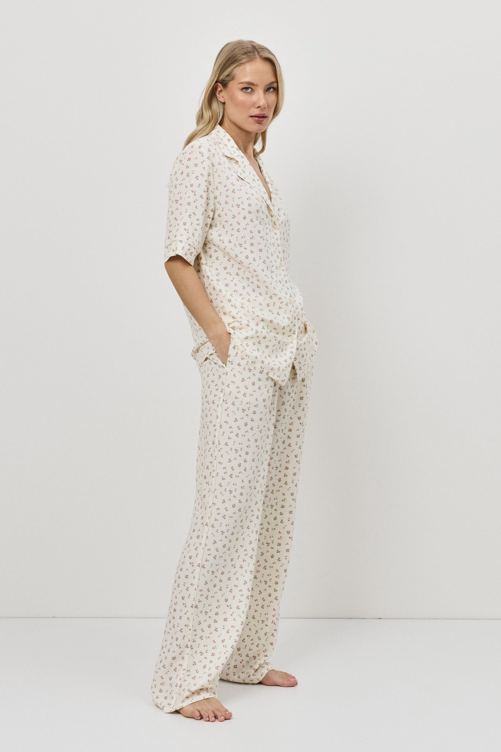 Woman wearing a white patterned outfit on a plain background