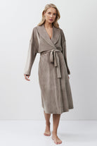 Woman wearing a capucine robe against a white background