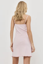 Woman wearing a light pink nightdress against a white background