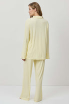 Woman wearing a light yellow outfit on a white background