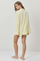 Woman wearing a light yellow dress against a white background