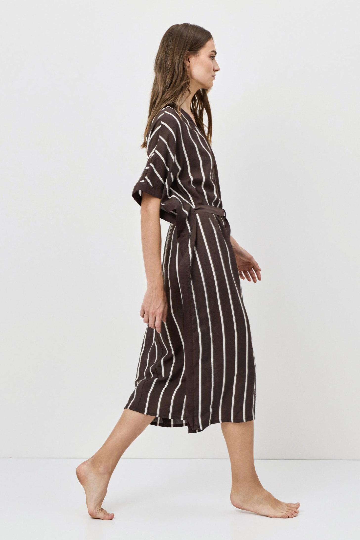 Woman wearing a striped dress on a white background