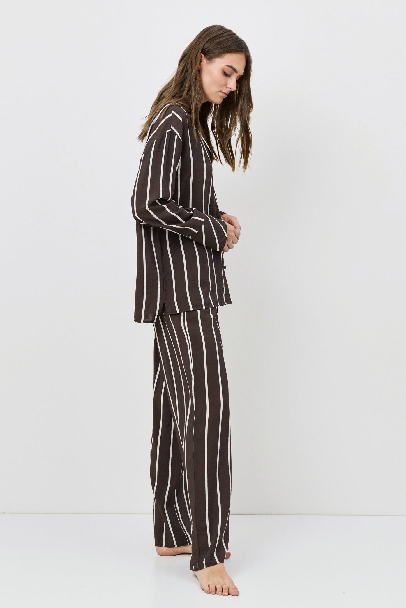 Woman wearing a black and white striped resort wear set against a white background