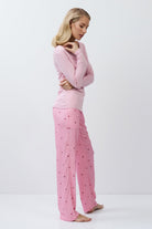 Woman wearing pink pajamas with a white background