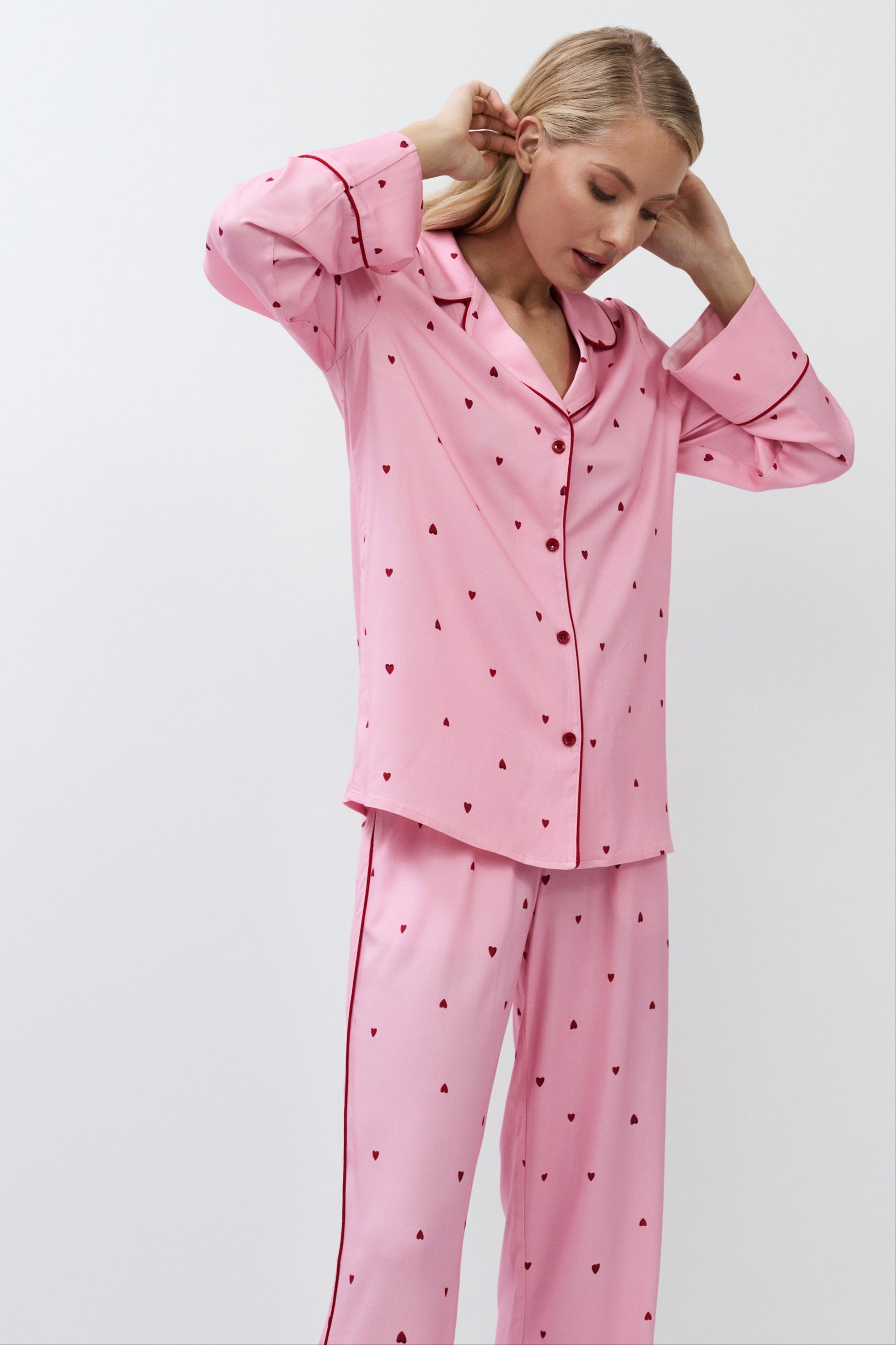 Woman wearing pink polka dot pajamas against a white background