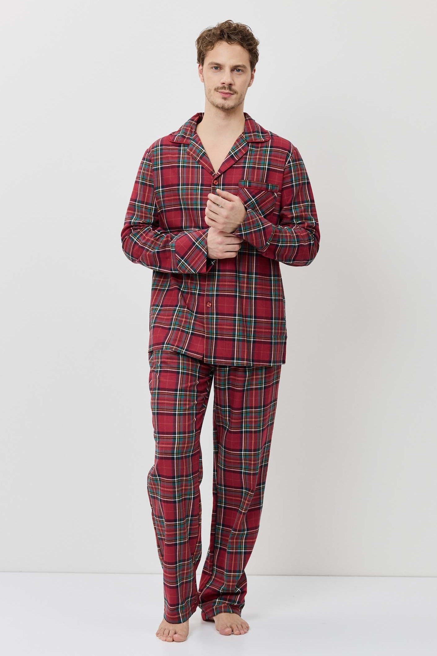 Man wearing red plaid pajama set on a white background