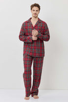 Man wearing red plaid pajama set on a white background
