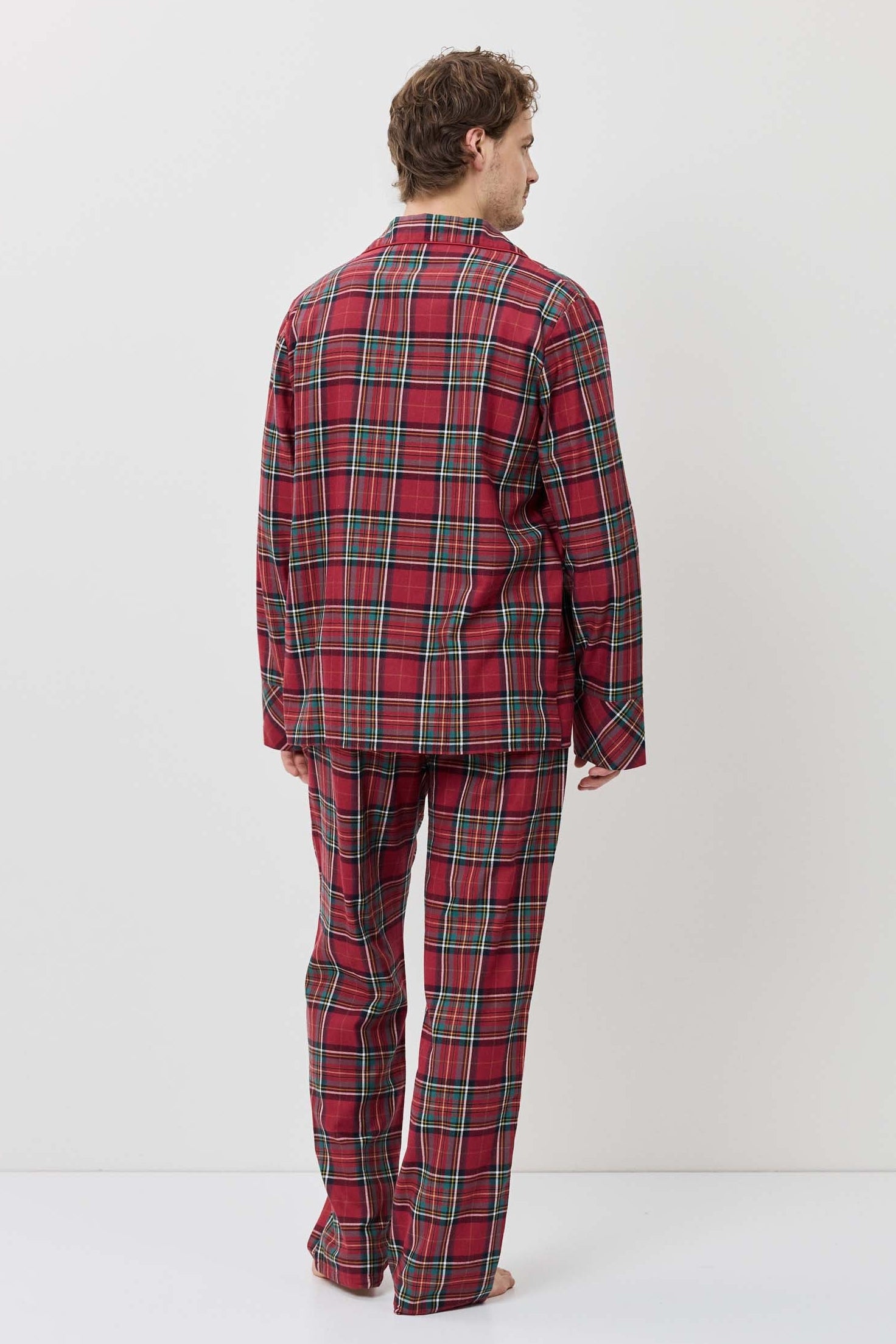 Person wearing a red plaid pajama set against a white background