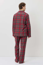 Person wearing a red plaid pajama set against a white background
