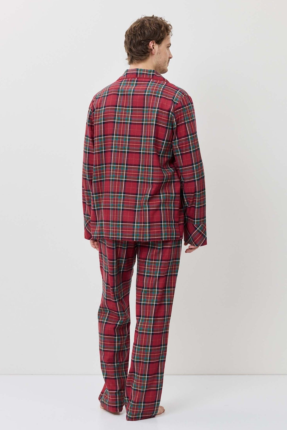 Person wearing a red plaid pajama set against a white background