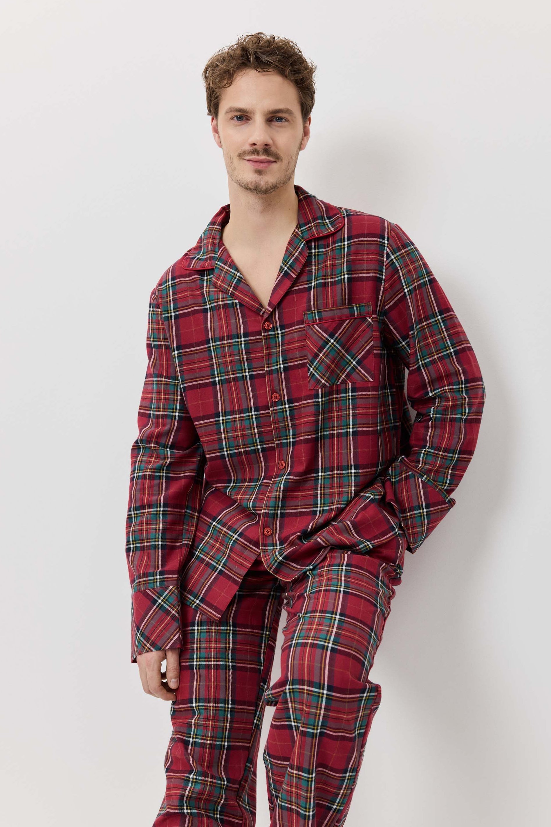 Man wearing red plaid pajamas against a white background