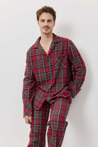 Man wearing red plaid pajamas against a white background