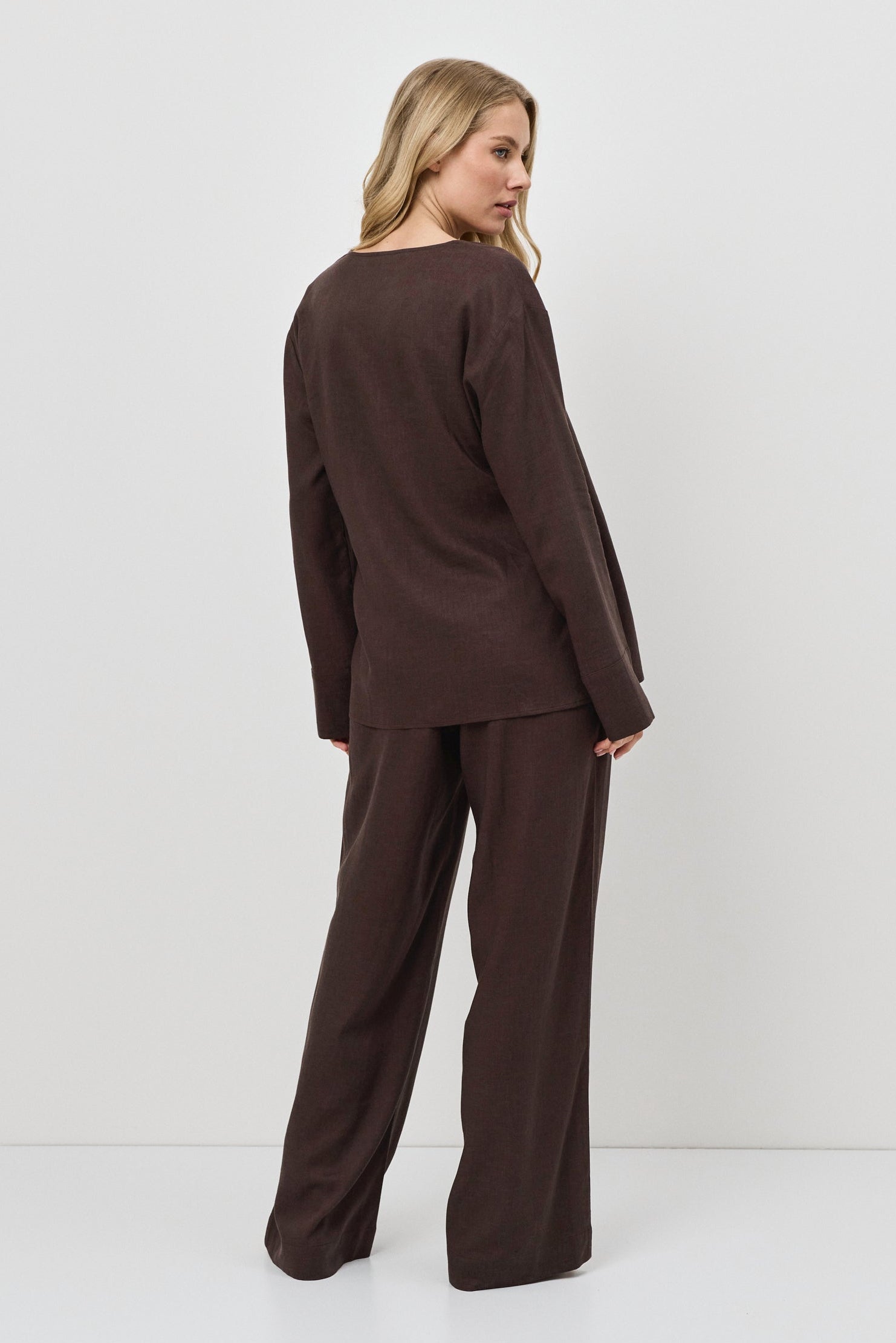 Woman wearing a brown resort wear set against a white background