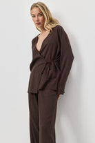 Woman wearing a brown resort wear set against a white background