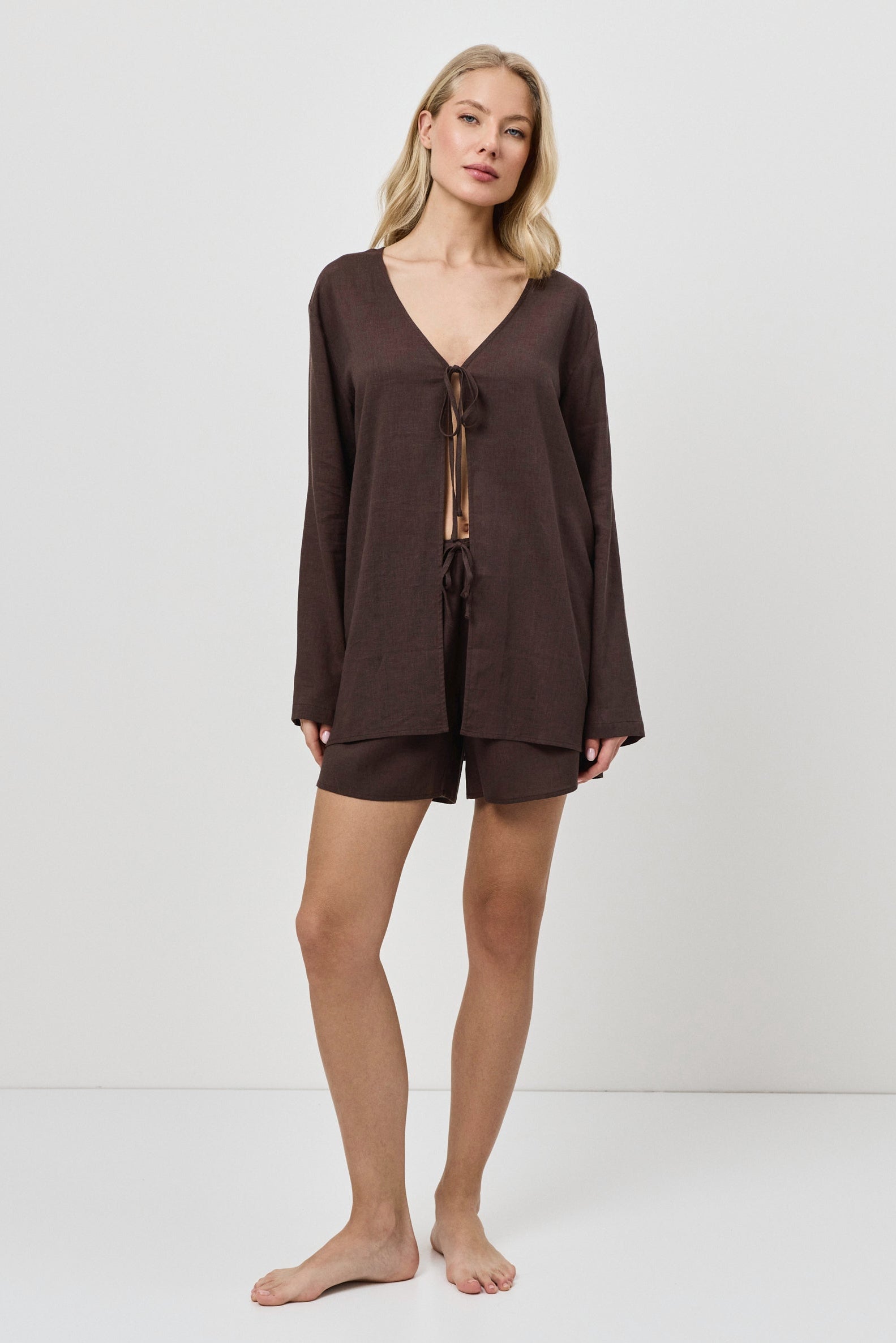 Woman wearing a brown resort wear set with a plain white background