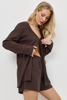 Woman wearing a brown resort wear set against a white background