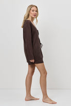 Woman wearing a brown resort wear set on a white background