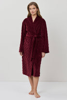 Woman wearing a burgundy robe on a white background