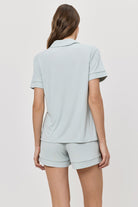 Woman wearing a light blue pajama set on a white background