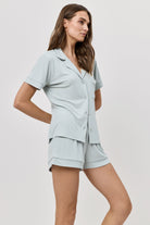 Woman wearing a light blue pajama set on a white background