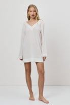 Woman wearing a white dress against a plain background