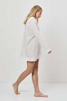 Woman wearing a white dress on a plain background