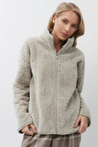 Woman wearing a sweater and plaid pants on a white background