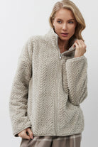 Woman wearing a beige jacket on a white background