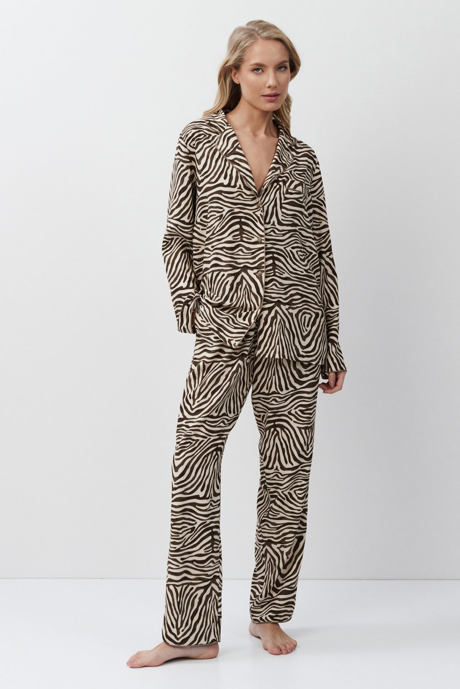Woman wearing a zebra print pajama set on a white background
