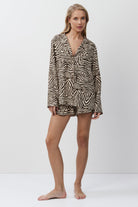 Woman wearing a zebra print shirt and shorts on a white background