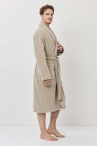 Man wearing a beige robe against a white background