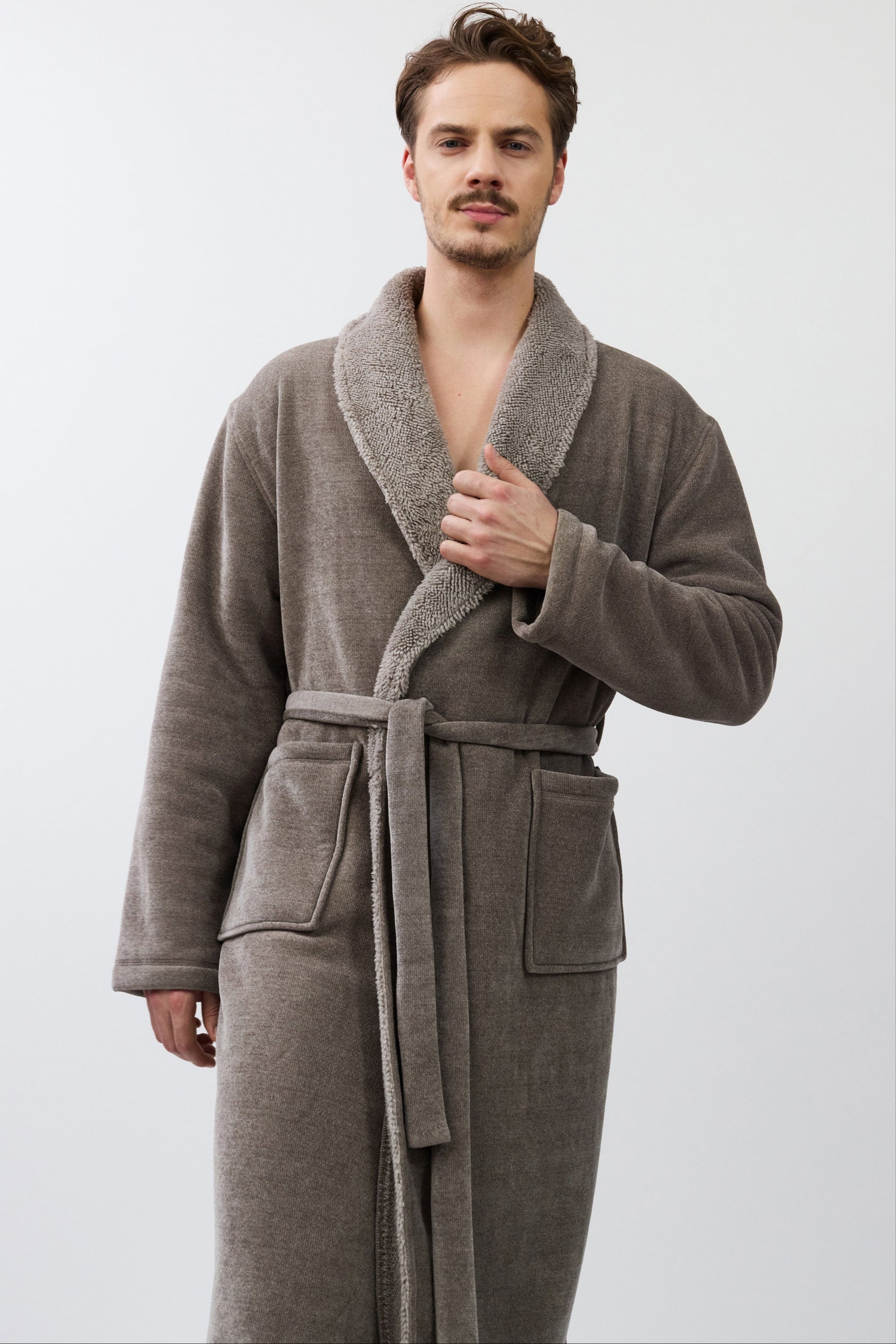 Man wearing a brown robe against a white background