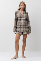 Woman wearing a plaid pajama set on a white background