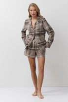 Woman wearing a plaid pajama set on a white background