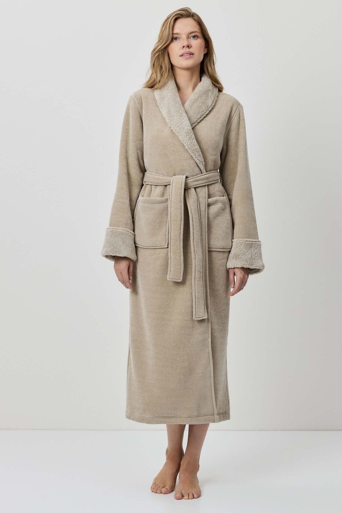 Woman wearing a beige robe against a white background