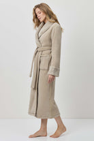 Woman wearing a beige robe against a white background
