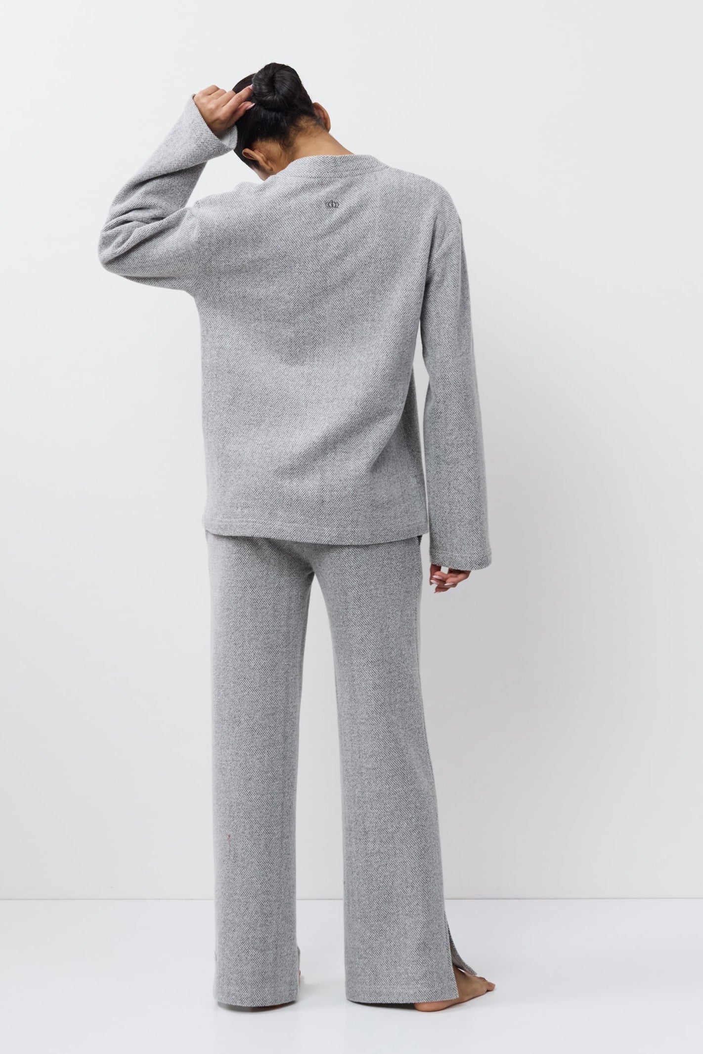 Person wearing a gray outfit on a white background