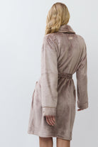 Woman wearing a choco bathrobe against a white background